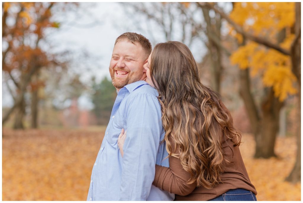 couple laughing at Norwalk Reservoir fall engagement session