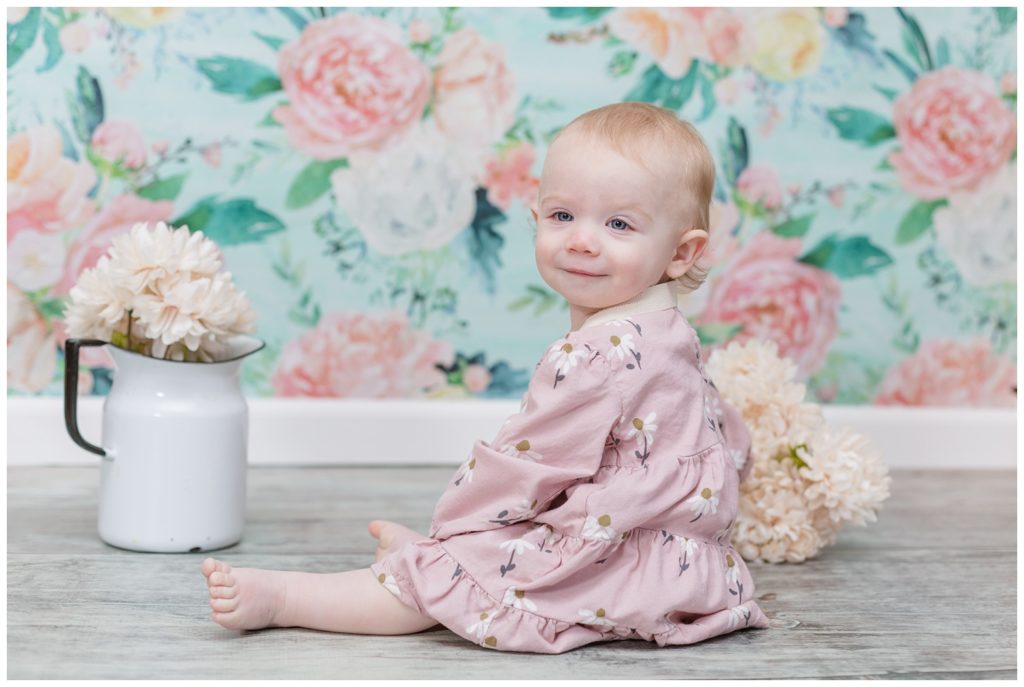 little girl wearing a pink dress at smash cake session