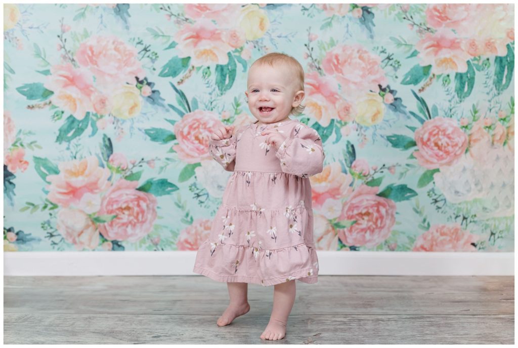 one year old girl wearing a pink dress for photo session