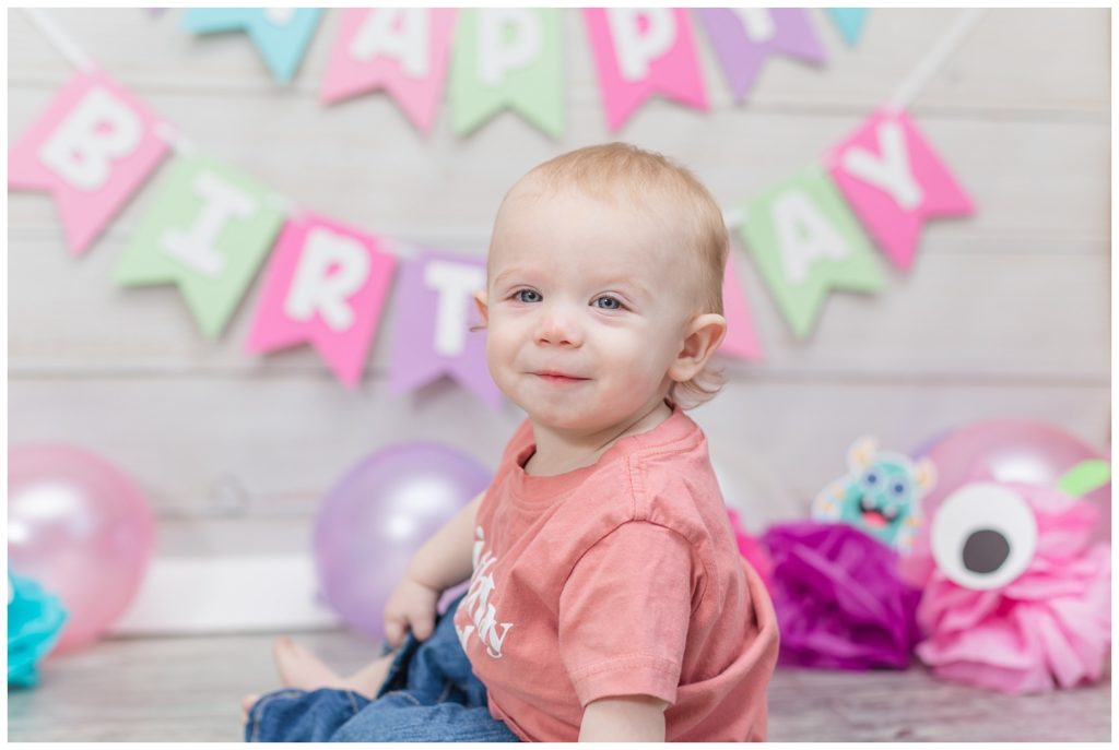 one year little girl sitting on the floor at birthday photo session