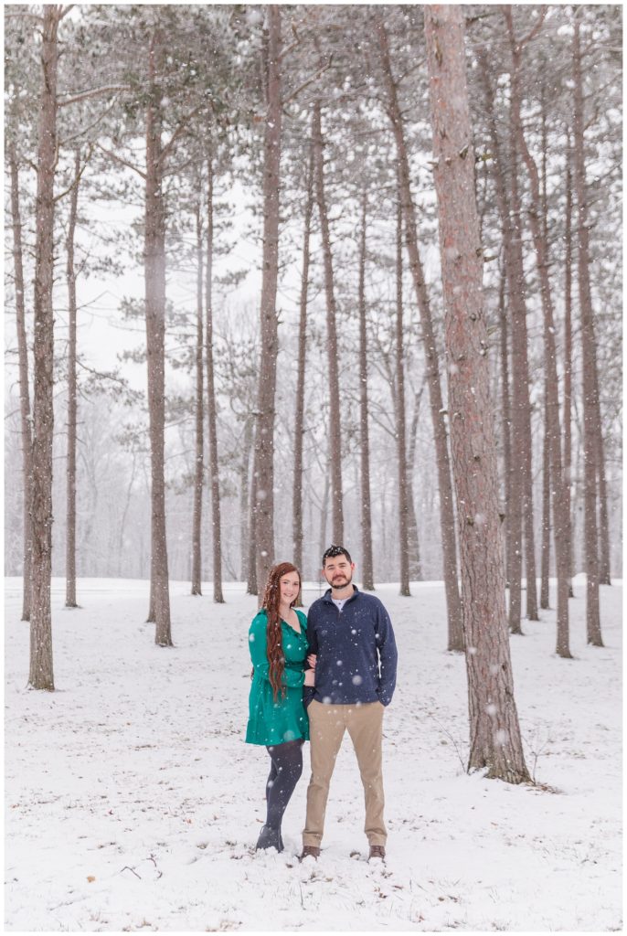 couple standing in front of trees and snow at Ohio engagement session
