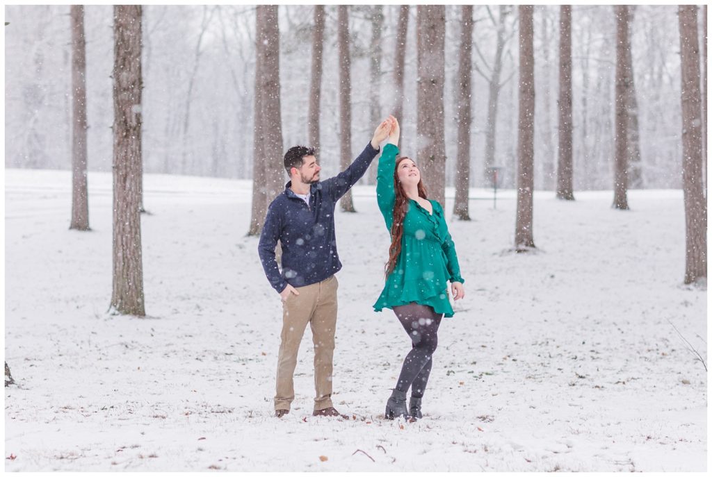 engaged couple dancing in the snow at Norwalk Reservoir