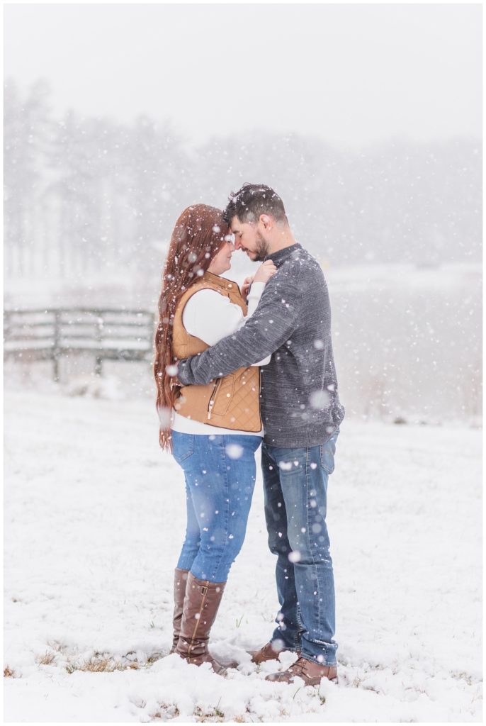 couple hugging in the snow at Norwalk Reservoir engagement session