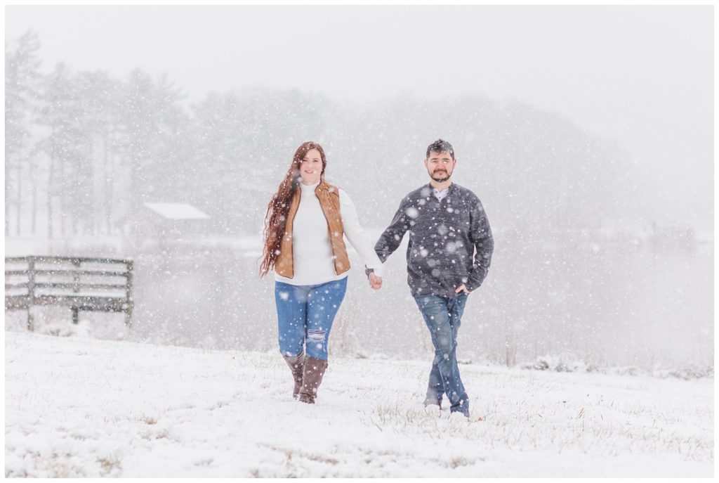 couple walking in the snow for winter engagement session in Ohio