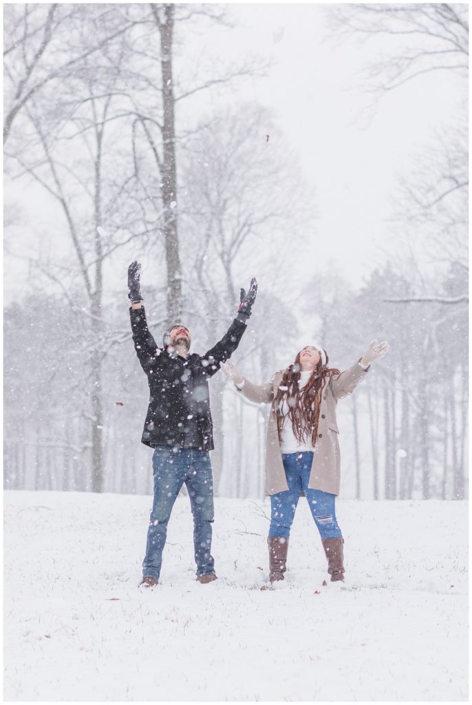 couple having a snowball fight at Ohio winter engagement session