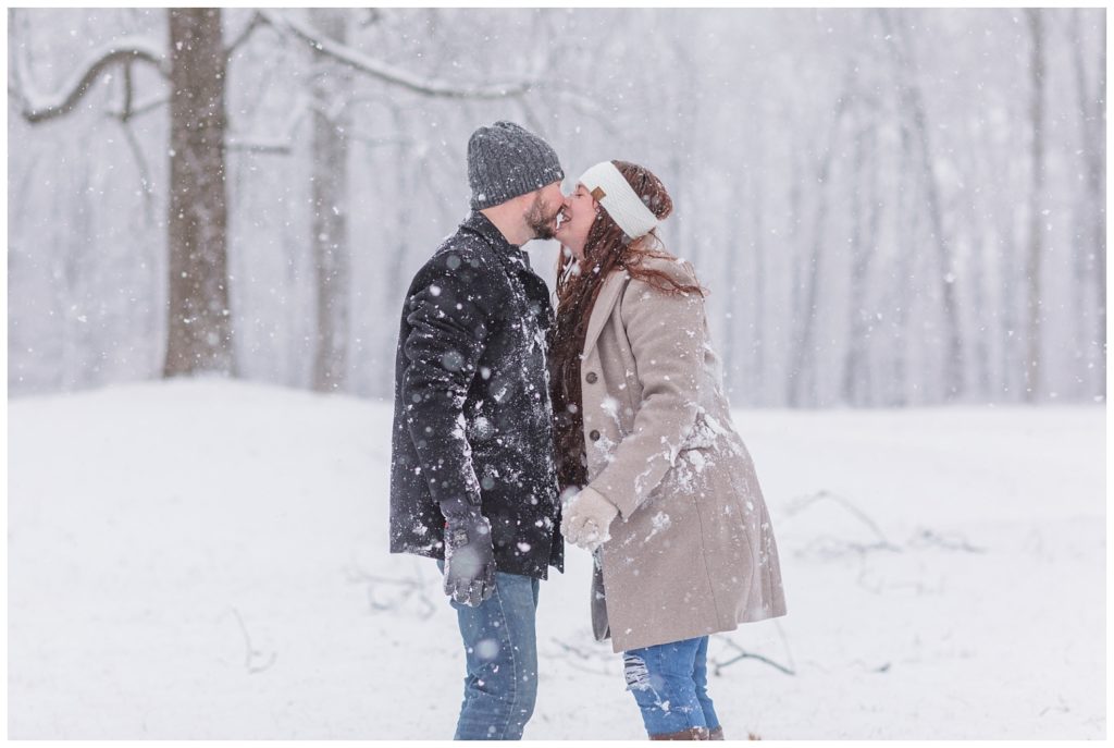 couple kissing in the snow at Norwalk Reservoir engagement session