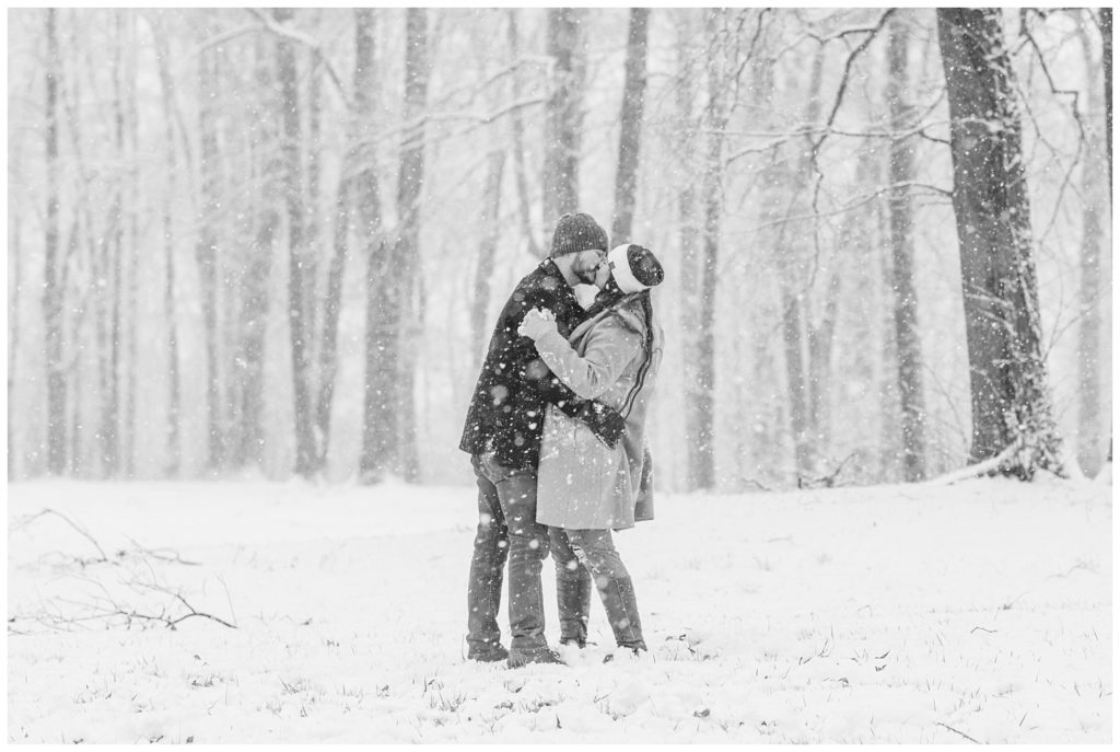 couple kissing in the snow at Norwalk Reservoir engagement session