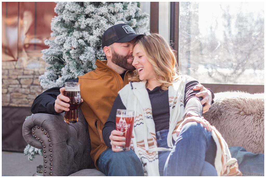 engaged couple sitting on a couch holding beers in Ohio