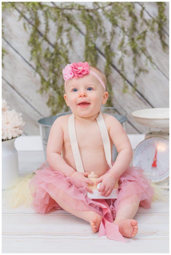 little girl wearing a pink tutu for her first birthday photo session