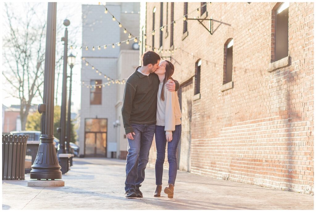 couple kissing for spring engagement photos in downtown Tiffin