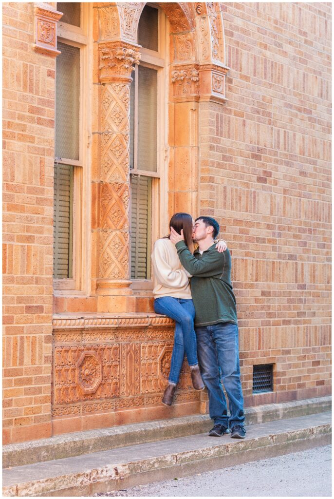 couple kissing in front of a red building in downtown Tiffin, Ohio