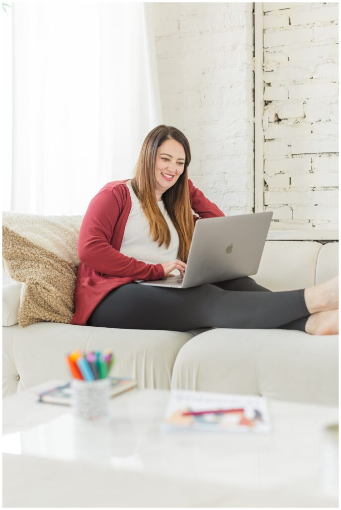 female business owner sitting on a couch with her laptop