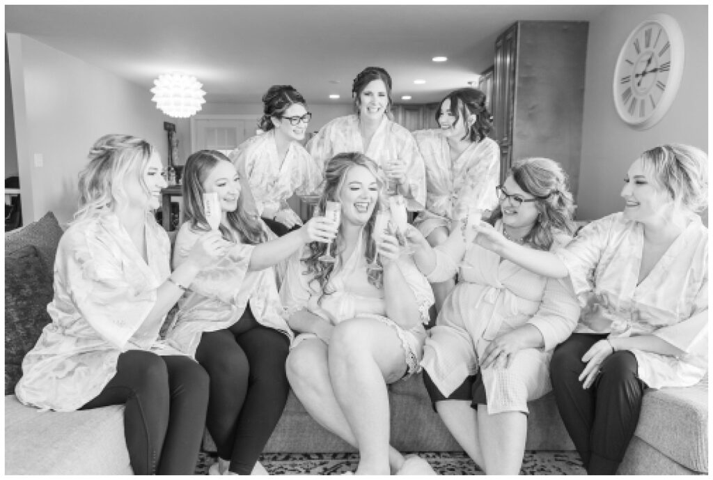 bridal party wearing silk robes and toasting champagne at the Village Barn