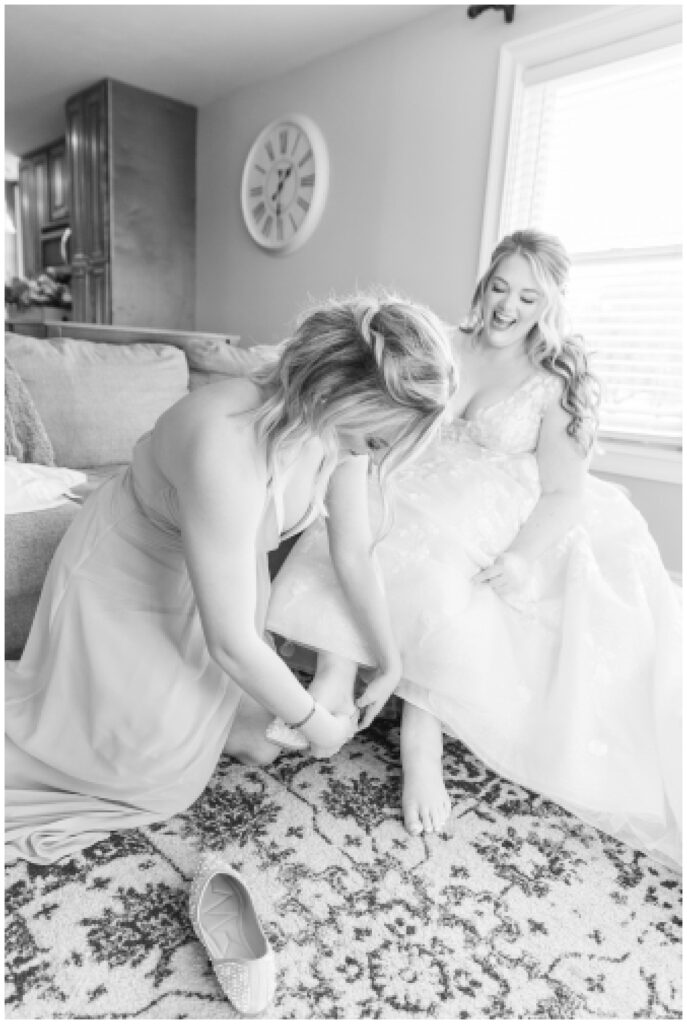 bride putting on her shoes at the Village Barn wedding venue 