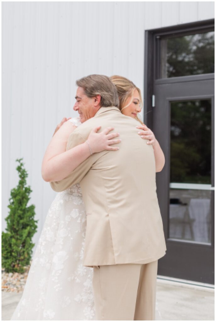 bride hugging her dad during first look at the Village Barn wedding venue