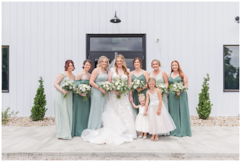 bridal party standing in front of the entrance to the Village Barn wedding venue