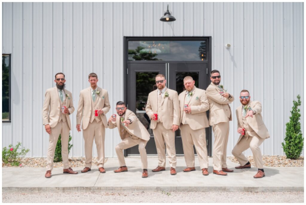 groomsmen wearing sunglasses and holding beers at summer wedding