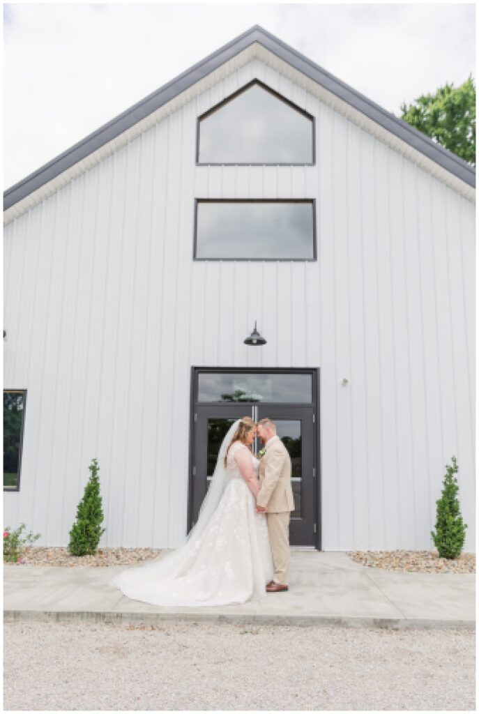 bride and groom holding hands in front of the Village Barn