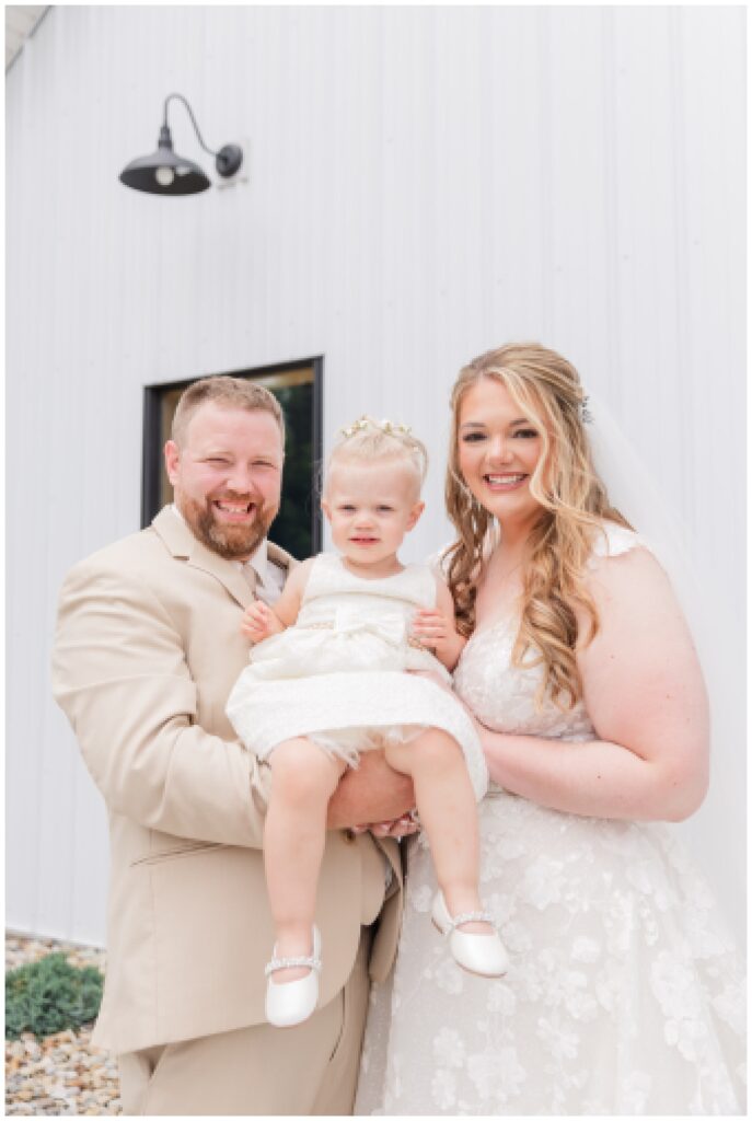 bride and groom holding daughter at Village Barn wedding in Ohio