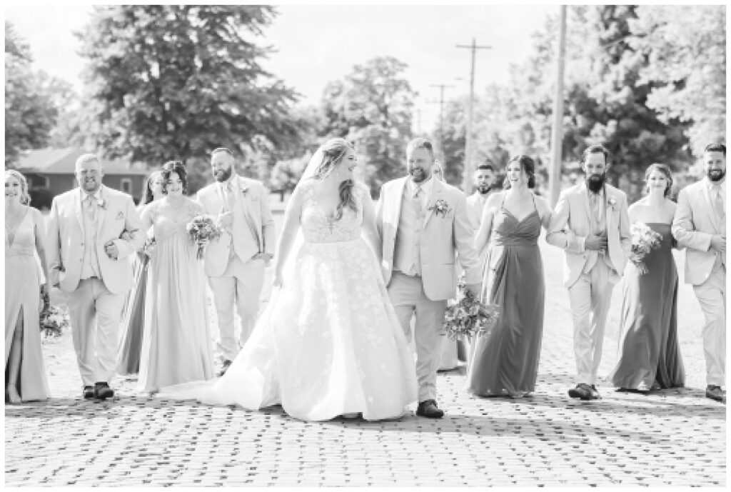 bride and groom walking with the wedding party on a brick road in Ohio