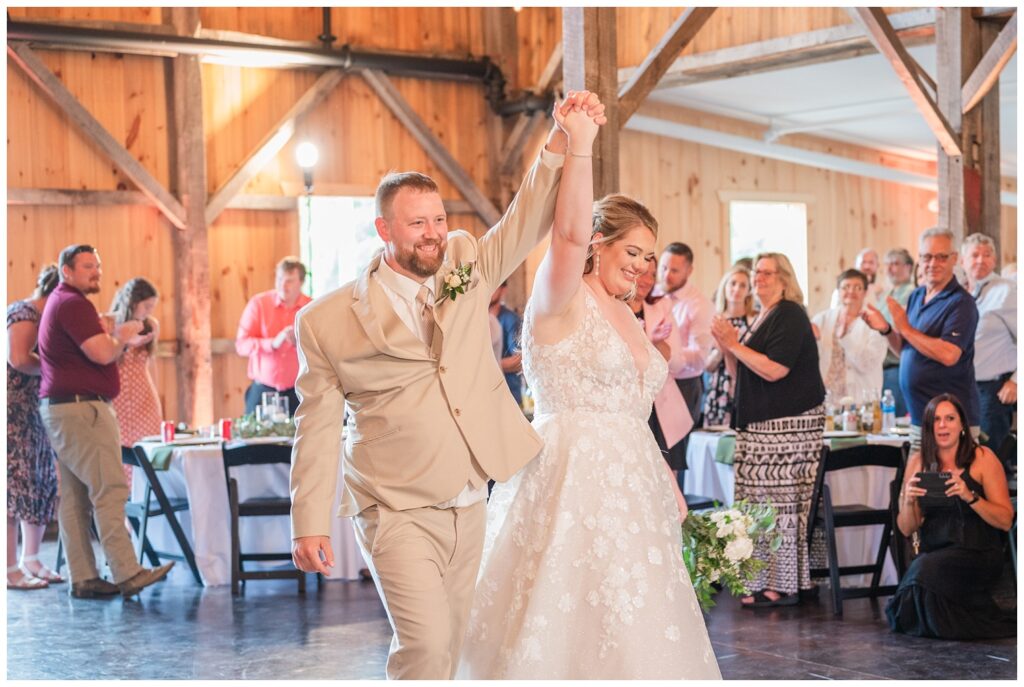 bride and groom's entrance into summer reception at the Village Barn