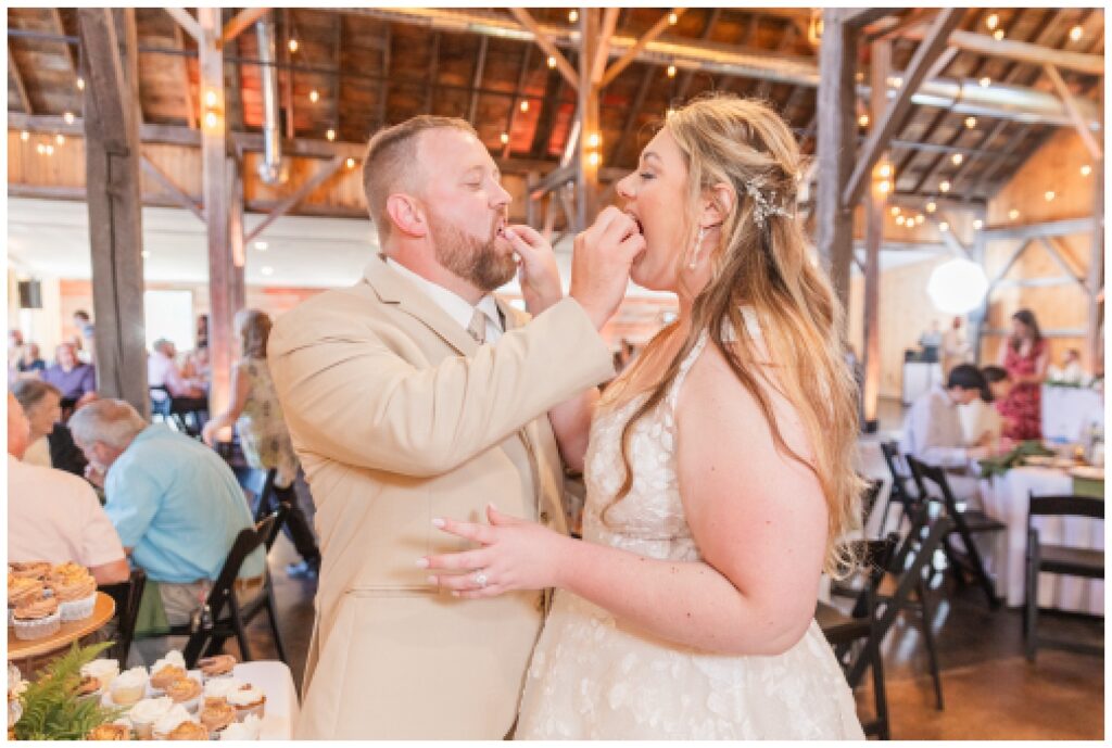 wedding couple feeding each other cake at reception in Monroeville, Ohio