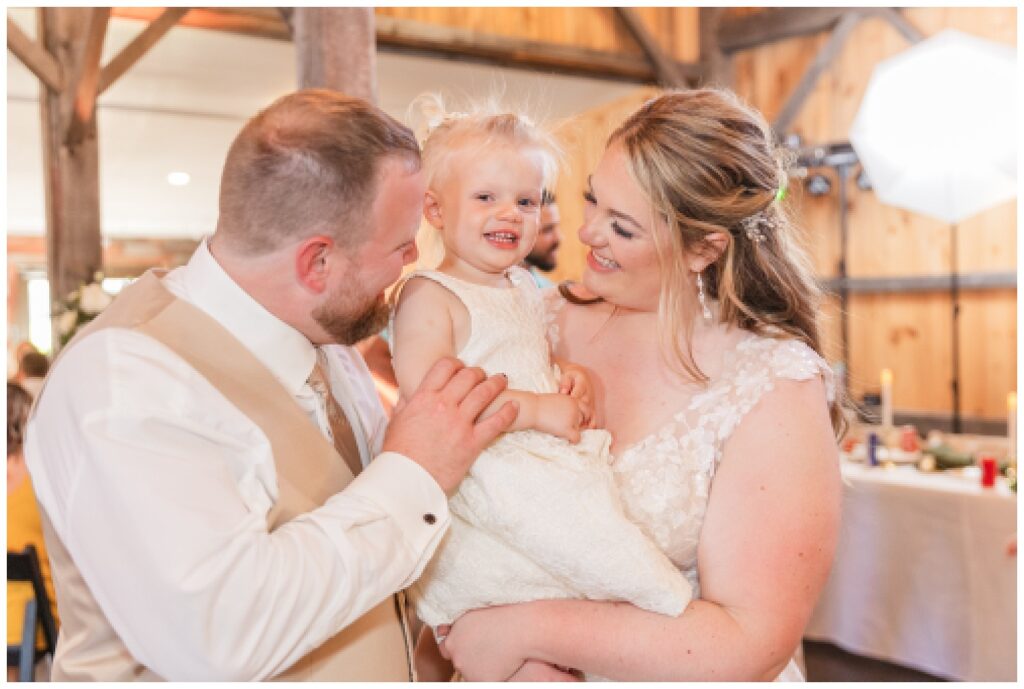 groom and bride holding their daughter at wedding reception in Monroeville, Ohio