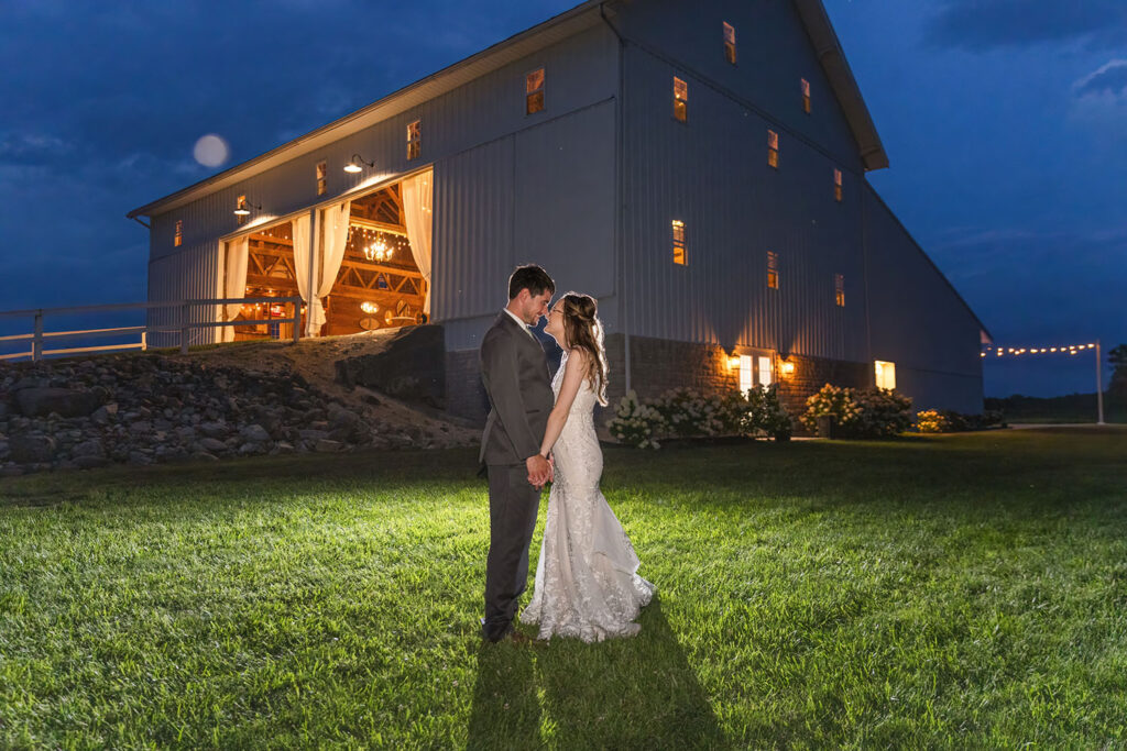 wedding couple posing at night in front of Arlington Acres wedding venue in Ohio