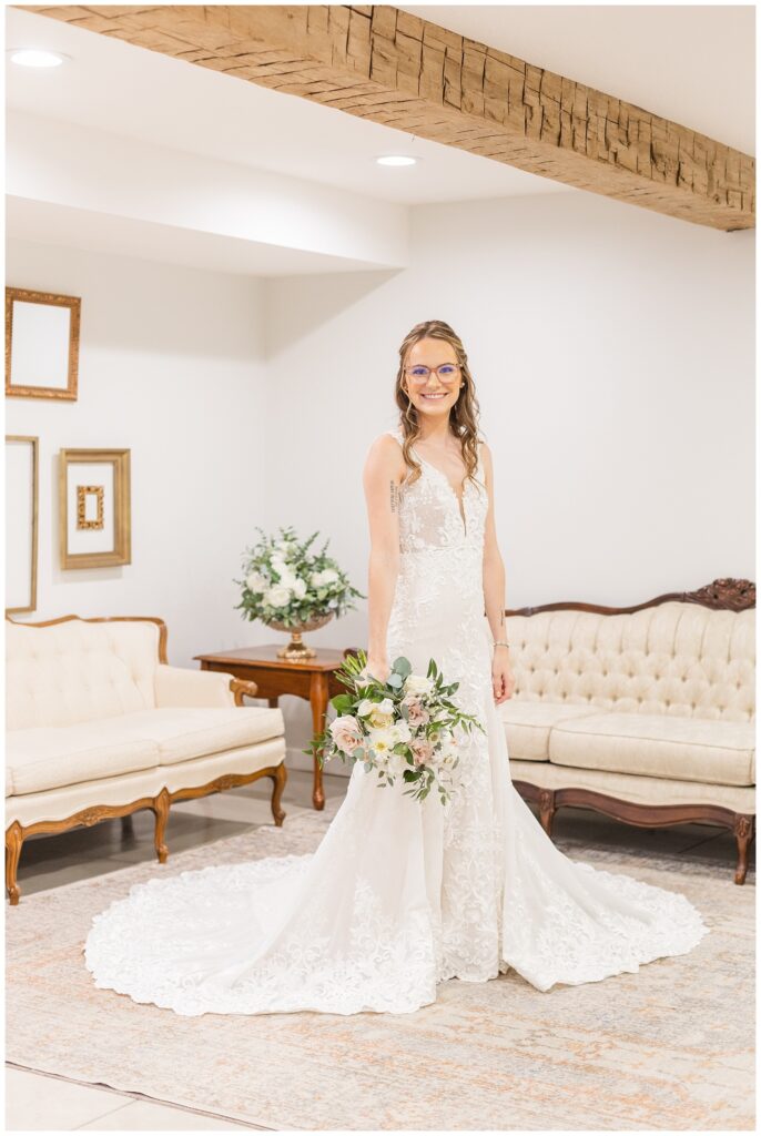 bride posing with bouquet in wedding dress in suite at Arlington Acres