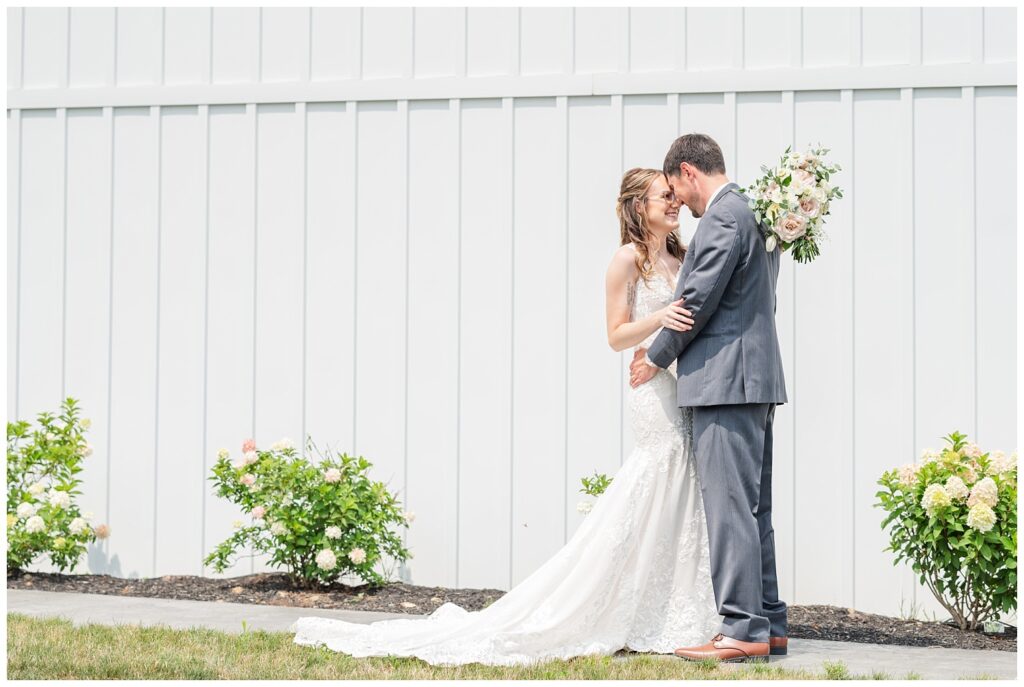 bride and groom posing in front of Arlington Acres wedding venue
