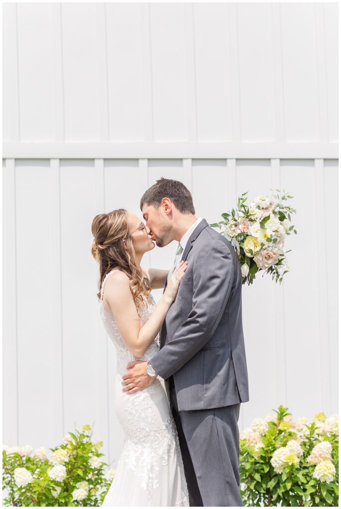 wedding couple kissing in front of Arlington Acres wedding venue