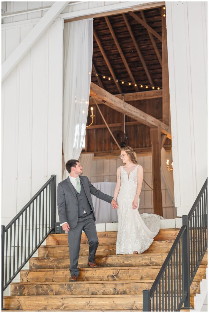 wedding couple walking down wood stairs at reception hall in Tiffin, Ohio