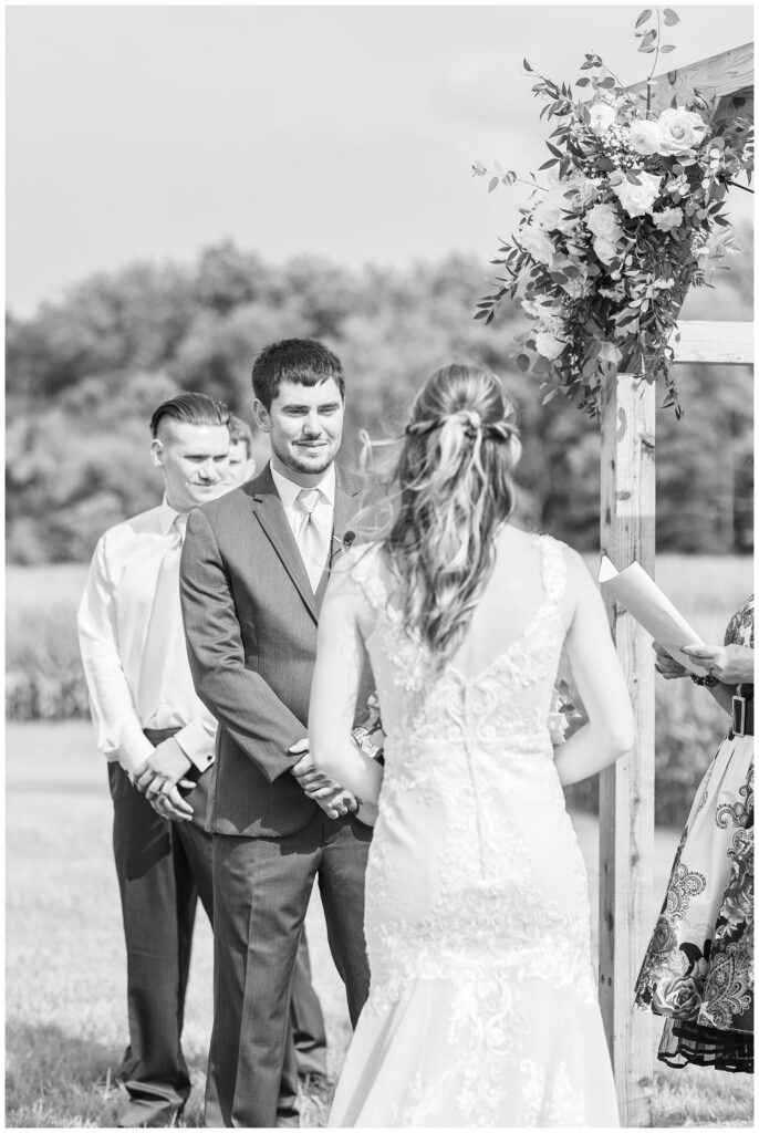 bride and groom at wooden arch for outdoors ceremony in Tiffin, Ohio