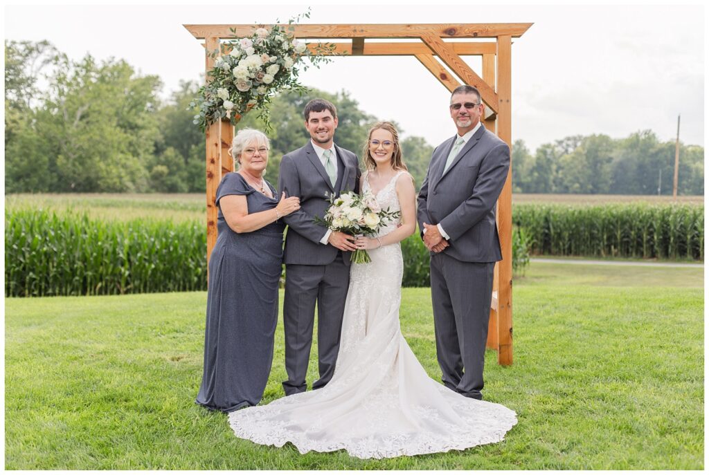 bride and groom posing with family at northwest Ohio wedding venue