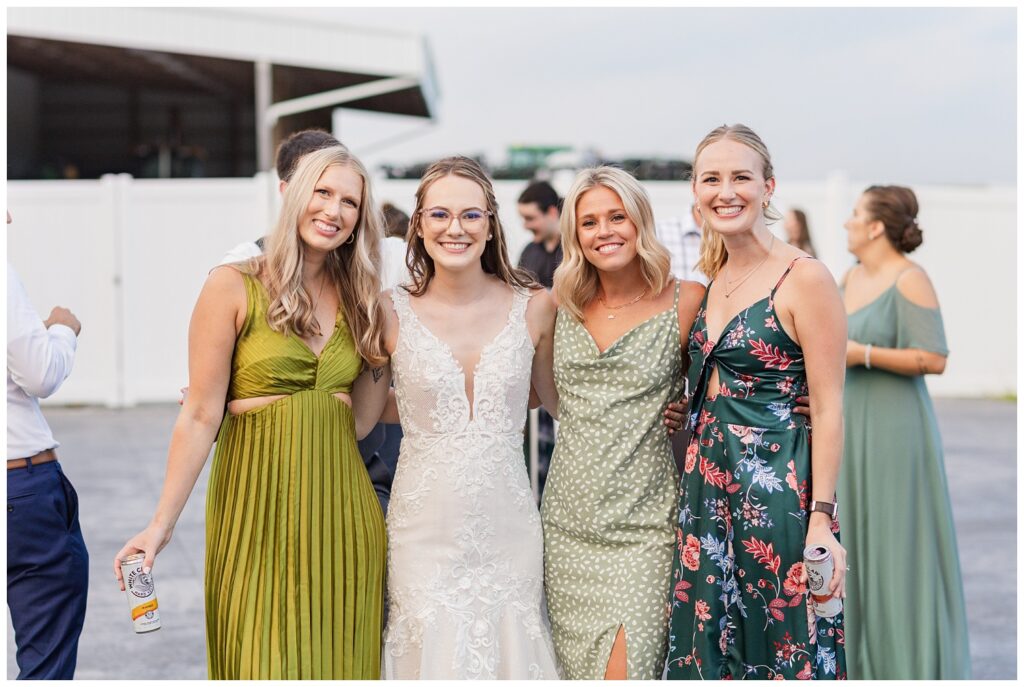 bride and her friends posing together at summer wedding reception