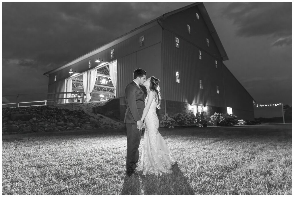 bride and groom share kiss at night outside at Arlington Acres wedding venue