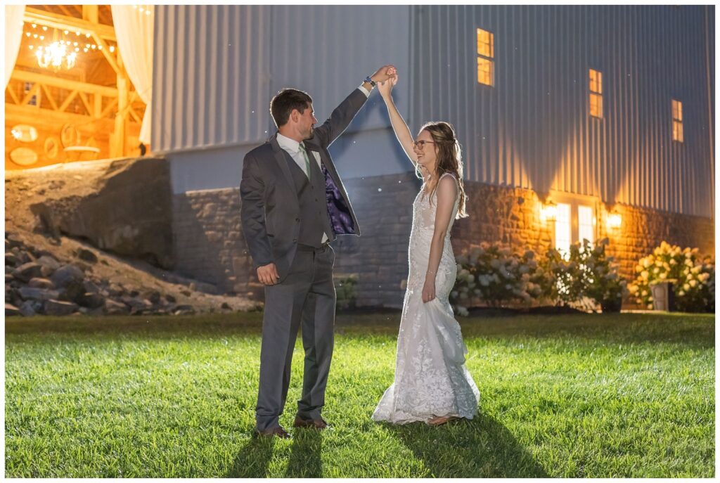 bride and groom twirling at night outside at Arlington Acres wedding venue