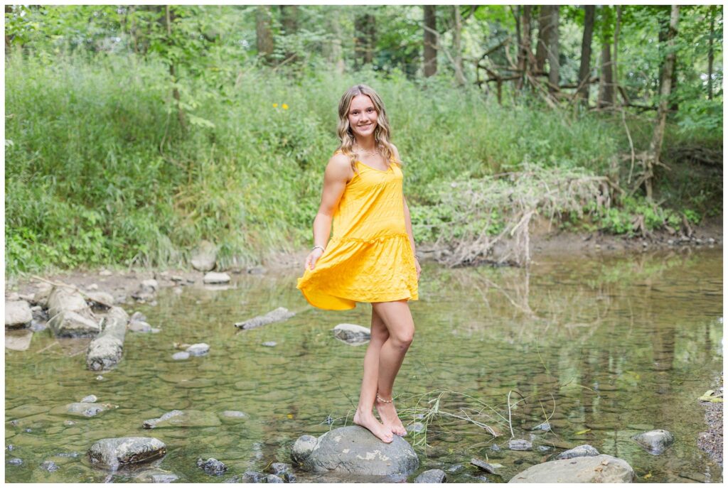 Ohio senior posing on a rock wearing a yellow dress 