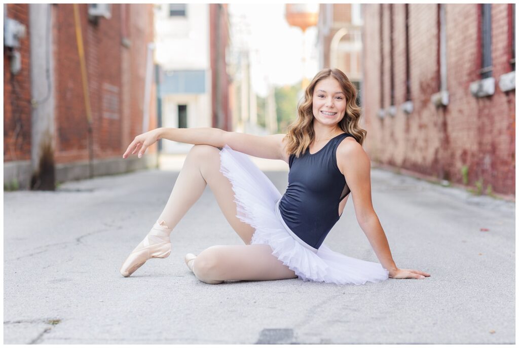 high school senior posing wearing a tutu and ballet shoes in downtown Gibsonburg