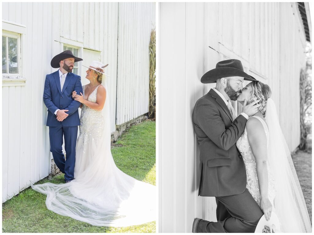 bride and groom posing next to a white barn wearing cowboy hats