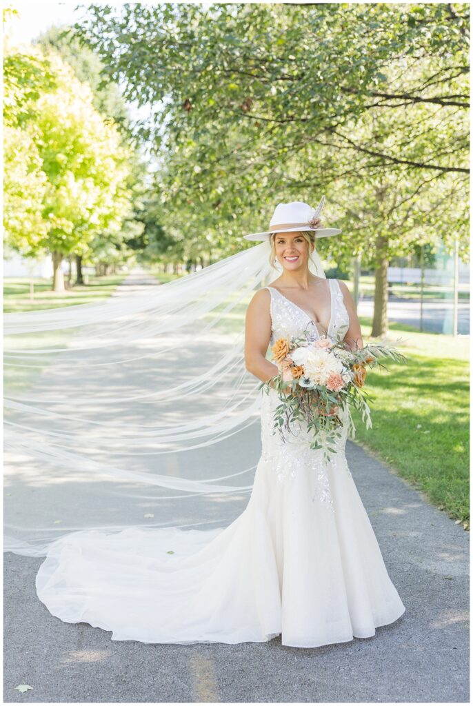 bride posing on the bike trail with veil blowing in the wind 