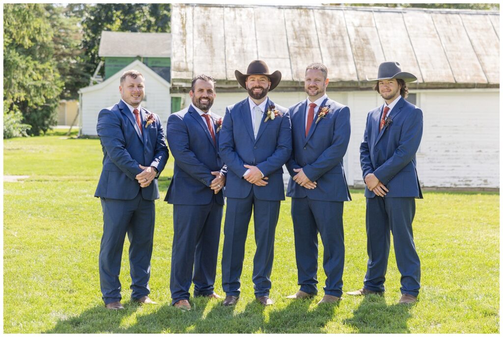 groomsmen posing in front of a white barn in Gibsonburg, Ohio