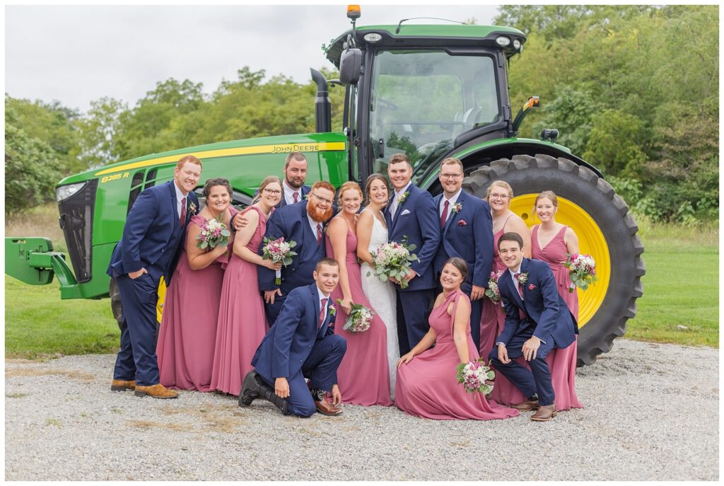 full wedding party posing with bride and groom's green tractor in Bowling Green, Ohio