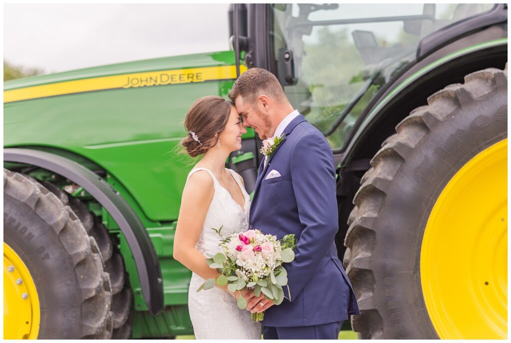 bride and groom posing in front of their green tractor in Bowling Green, Ohio
