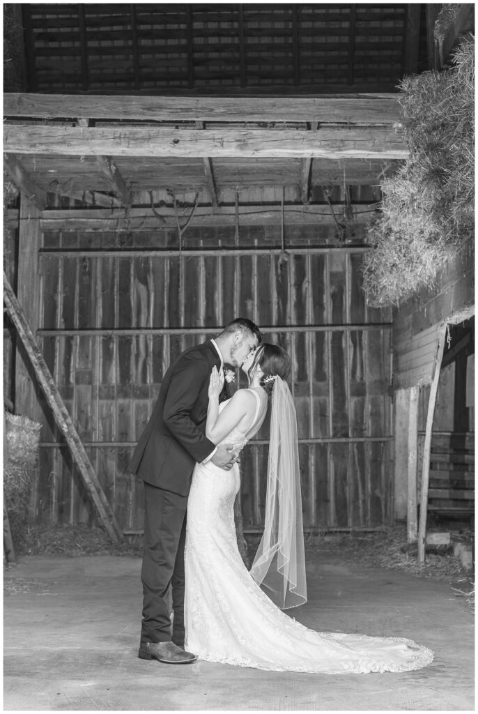 wedding couple share a kiss inside their barn in Bowling Green, Ohio