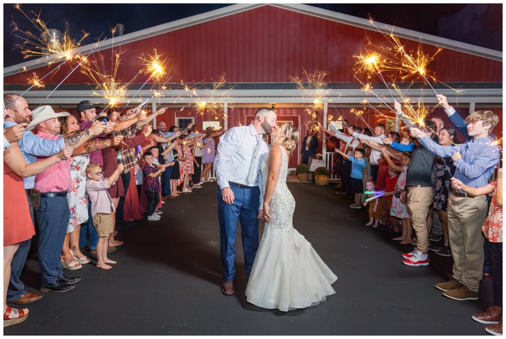 bride and groom kiss during sparkler exit at Ole Zim’s Wagon Shed wedding venue