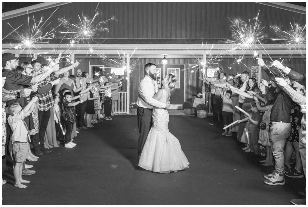 bride and groom pose at sparkler exit at Ole Zim’s Wagon Shed wedding venue