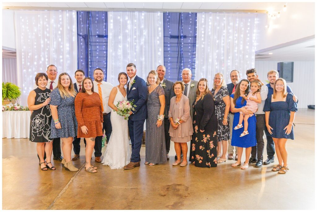 wedding guests posing with bride and groom at fall reception in Ohio