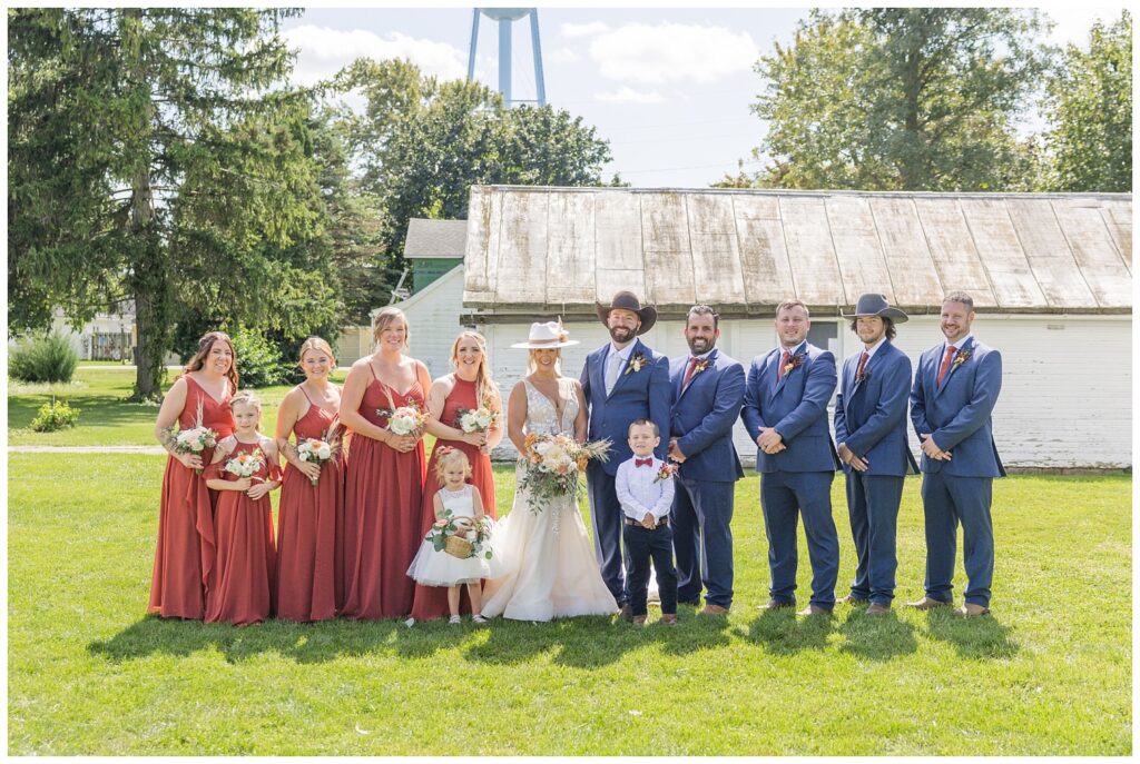 full wedding party posing in front of a white barn in Gibsonburg, Ohio