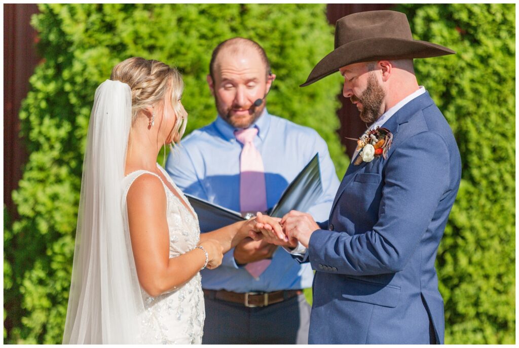 bride and groom exchange rings at Ole Zim's Wagon Shed venue